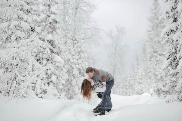 Un jeune couple hipster s'embrasse dans un parc d'hiver. Vacances d'hiver. Vacances de Noël en plein air en forêt — Photo