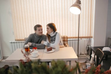 Birbirine aşık çift bir kafede dinleniyor. Çift çok güzel bir genç adam ve kadın. Birkaç kişi çay içiyor. İnsanlar birbirine bakar. - İnsanlar mutlu ve gülümsüyor. Gündüz.