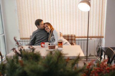 Birbirine aşık çift bir kafede dinleniyor. Çift çok güzel bir genç adam ve kadın. Birkaç kişi çay içiyor. İnsanlar birbirine bakar. - İnsanlar mutlu ve gülümsüyor. Gündüz.