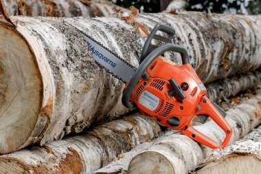 KIROV, Rusya - 09.10.2020. Husqvarna 236 Chainsaw. Elektrikli testereyle odun kesiyor, kışa odun hazırlıyor, kırsal alanda sıkı çalışıyor.