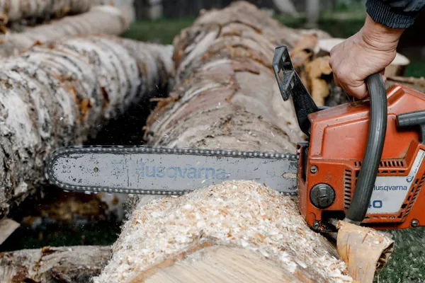 KIROV, Russia - 09.10.2020. Husqvarna 40 Chainsaw. Man saws a log with a chainsaw, prepares firewood for winter, hard rural work — Stock Photo, Image