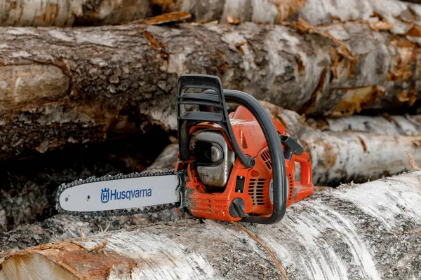 Kirov, Russia - 09.10.2020 Husqvarna 236 chainsaw stands on logs. global brand of garden equipment — Stock Photo, Image