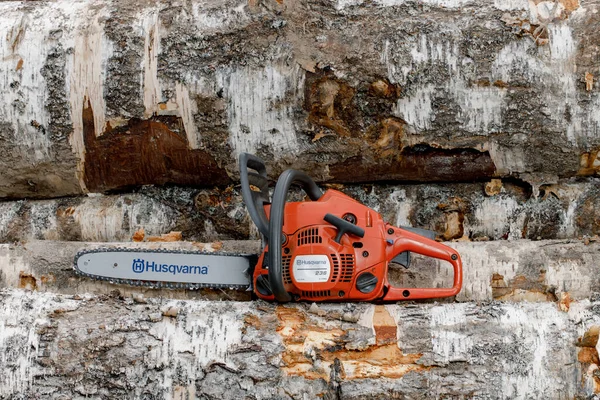 Kirov, Russie - 09.10.2020 Husqvarna 236 chainsaw stands on logs. marque mondiale d'équipement de jardin — Photo