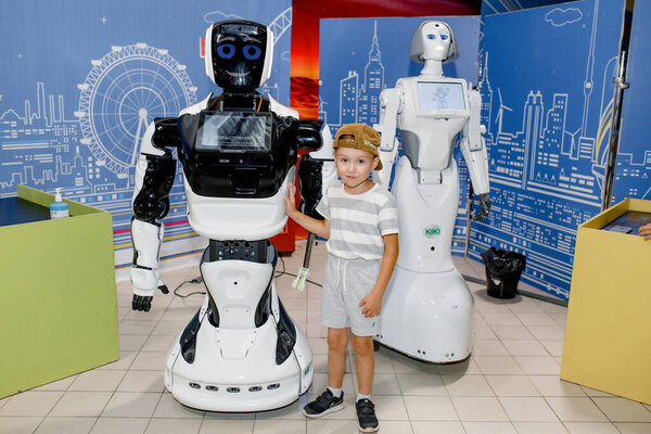 КИРОВ, РОССИЯ - 4 августа 2021 года: Мальчик стоит рядом с роботом-промоботом и WIKI на выставке. Роботы консультанты.