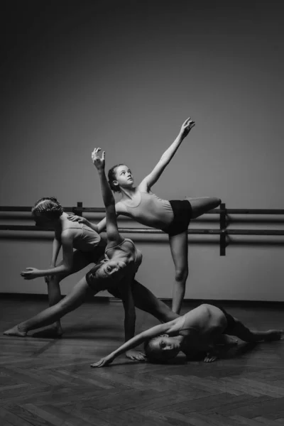 Imagem em preto e branco de um grupo de pequenas bailarinas modernas em pé em uma pose de dança moderna. Espaço de cópia — Fotografia de Stock