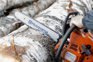 KIROV, Rusya - 09.10.2020. Husqvarna 236 Chainsaw. Elektrikli testereyle odun kesiyor, kışa odun hazırlıyor, kırsal alanda sıkı çalışıyor.. 
