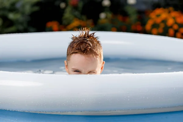 Porträt eines lustigen weißen Kindes, das aus dem Pool guckt — Stockfoto