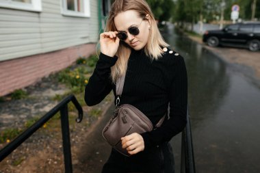 Güneş gözlüklü güzel, sarışın bir kızın görüntüsü. Profilde 30 yaşında bir kızın portresi