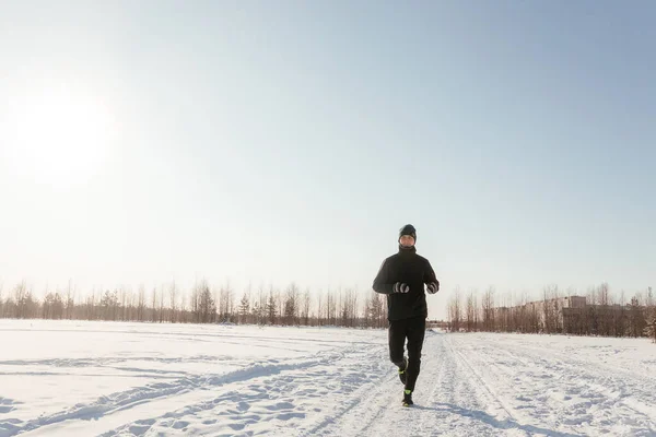 Karlı bir kış gününde doğada koşan orta yaşlı mutlu bir sporcunun tam uzunluğu. Açık hava fitness, kardiyo eğitimi, açık hava egzersizleri. Boşluğu kopyala 