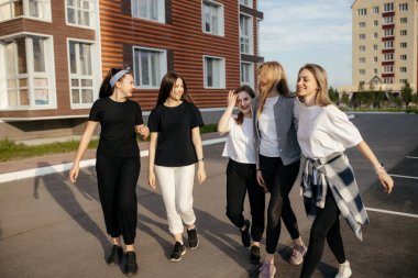 Bir grup mutlu genç kız şehirde geziyor, eğleniyor ve gülüyorlar. Rahatlama ve kız arkadaşlığı kavramı. 