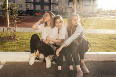 Mutlu arkadaşlar şehrin gün batımında birbirlerine sarılıyorlar.