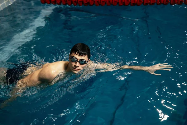 白人运动员 游泳运动员在蓝色的水里爬行 一个穿着泳镜游泳的年轻男子三项全能运动员的画像 三项全能运动员训练概念 — 图库照片