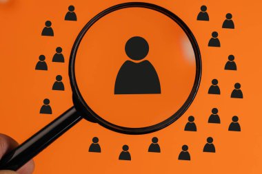 Kırmızı arka planda bir adamın ikonunun olduğu bir büyüteç tutuyor. Bir insanı arama kavramı, yetenek, potansiyel bir çalışan büyüteç kullanıyor.