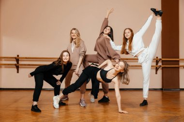 Spor giyimli bir grup kız dans stüdyosunda dans ederek dans ediyorlar. Zevkle dans ediyorlar. Spor gençliği kavramı. 