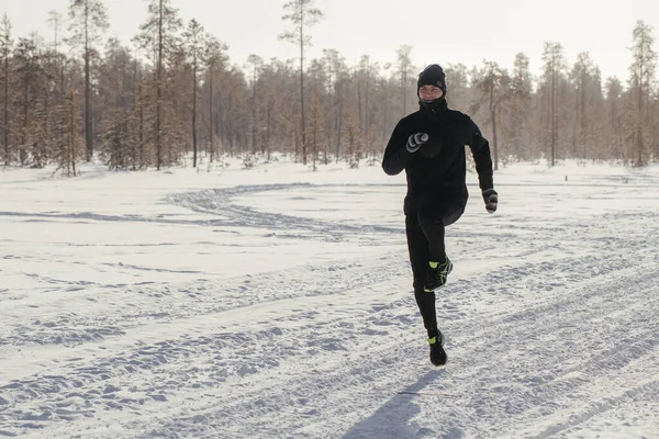 Egy boldog középkorú sportoló teljes hossza, aki a természetben fut egy havas téli napon. Szabadtéri fitnesz, kardio edzés, szabadtéri gyakorlatok — Stock Fotó