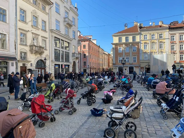 3月18 、 2022 -ウクライナのリヴィウ:ウクライナに対するロシアの戦争で死亡した子供たちを記念して市内のメイン広場に空の赤ちゃん馬車の設置. — ストック写真
