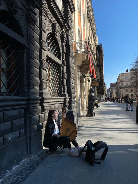 18 марта 2022 - Львов, Украина: Молодая девушка в центре Львова играет на бандуре украинского национального инструмента — стоковое фото