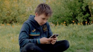 Ukraynalı çocuk akıllı telefondan video oyunu oynuyor
