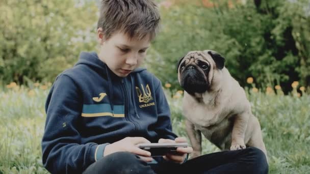 Ukrainian refugee boy playing video game on smarthphone — Stock videók