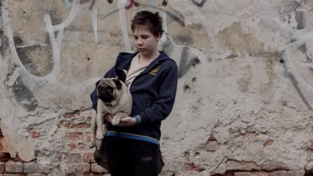Ukrainian teenage boy holding a pug — Stok video