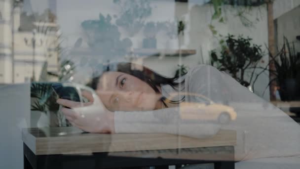 Λυπημένη Βαριεστημένη Νεαρή Γυναίκα Στο Καφέ Χρησιμοποιώντας Smartphone Ξαπλωμένη Στο — Αρχείο Βίντεο