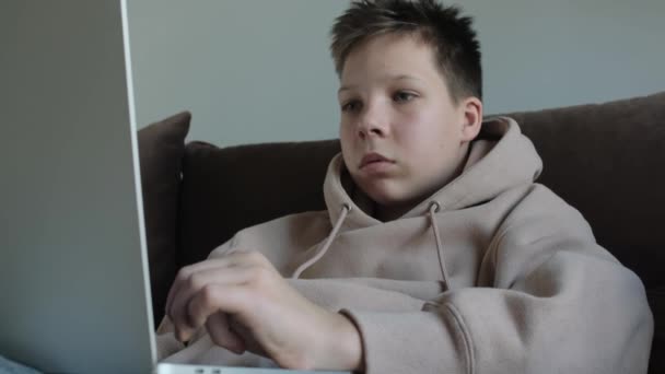 Adolescente Caucasiano Menino Com Capuz Usando Laptop Deitado Sofá — Vídeo de Stock