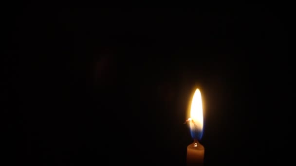 Una fiamma di candela di notte primo piano isolato — Video Stock