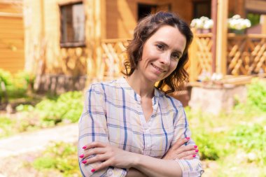 Bir kadın bahçesinde bahçeyle uğraşıyor, fideleri ekiyor..