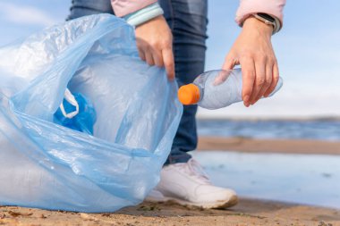 Kadın bir gönüllü doğadaki plastik çöpleri temizliyor..