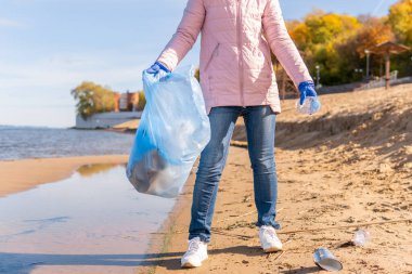 Kadın bir gönüllü doğadaki plastik çöpleri temizliyor..