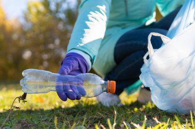 Kadın bir gönüllü doğadaki plastik çöpleri temizliyor..