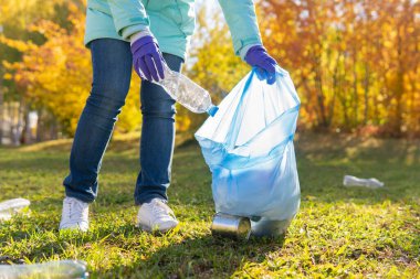 Kadın bir gönüllü doğadaki plastik çöpleri temizliyor..