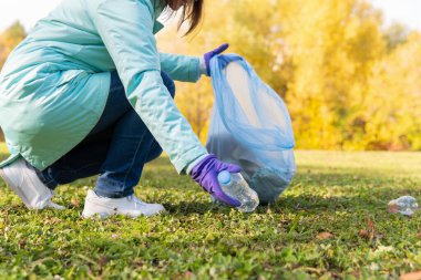 Kadın bir gönüllü doğadaki plastik çöpleri temizliyor..