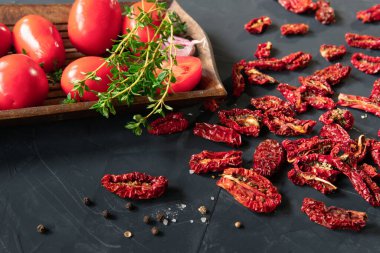 Kurutulmuş domatesler mutfakta koyu bir arka planda..