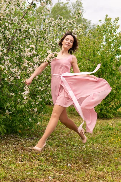 Kobieta w pobliżu kwitnącego wiosennego drzewa. Romantyczny szczęśliwy nastrój. — Zdjęcie stockowe