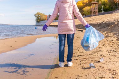 Kadın bir gönüllü doğadaki plastik çöpleri temizliyor..