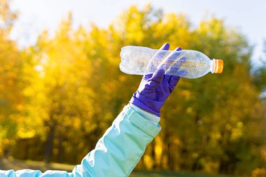 Kadın bir gönüllü doğadaki plastik çöpleri temizliyor..