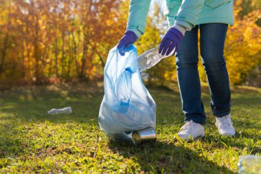 Kadın bir gönüllü doğadaki plastik çöpleri temizliyor..