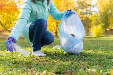 Kadın bir gönüllü doğadaki plastik çöpleri temizliyor..
