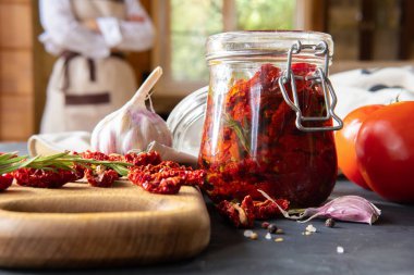 Mutfak masasında bir kavanoz kurutulmuş domates ve sarımsak..