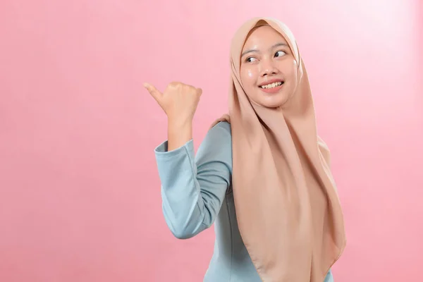 年轻的亚洲穆斯林妇女微笑的要点旁边的复制空间显示广告穿着穆斯林休闲装 — 图库照片