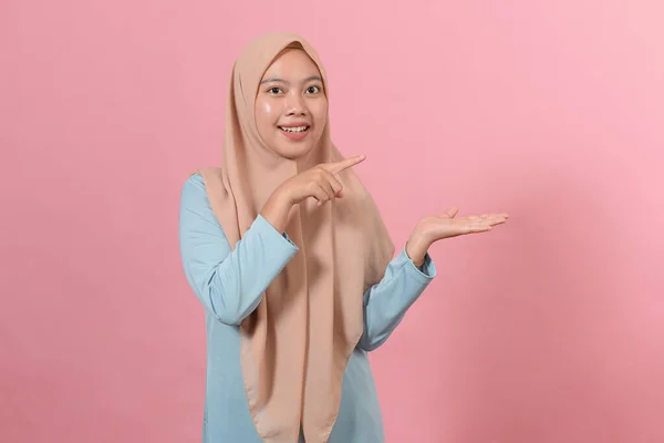 Mujer Musulmana Joven Posando Fondo Rosa Aislado Excitado Sosteniendo Espacio —  Fotos de Stock