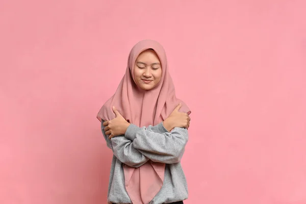 若いですかなりイスラム教徒女性感じで愛 抱きしめと抱擁自己 滞在シングルとEgocentricに対してピンクの背景 — ストック写真