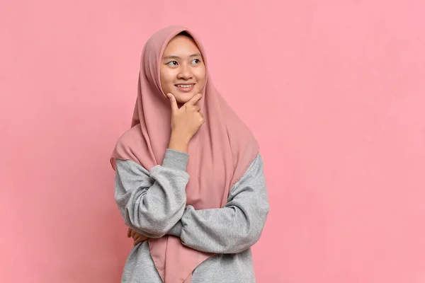 若いアジアのイスラム教徒の女性は コピースペースを見たり アイデアを考えます ピンクの背景に隔離された — ストック写真