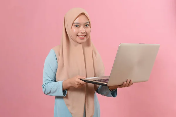 Gülümseyen Müslüman Kadın Pembe Arka Planda Dizüstü Bilgisayar Kullanıyor — Stok fotoğraf