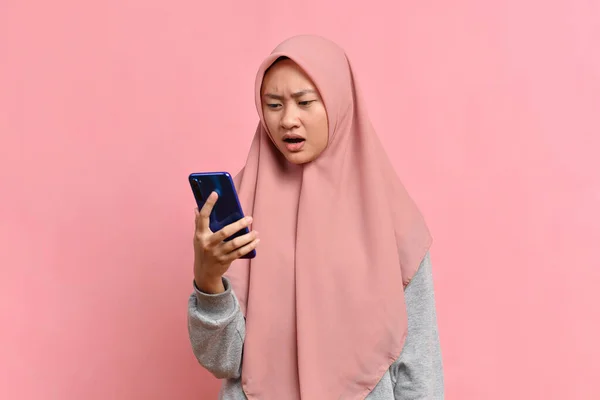 Проблемная Мусульманка Смотрит Мобильный Телефон Розовом Фоне — стоковое фото