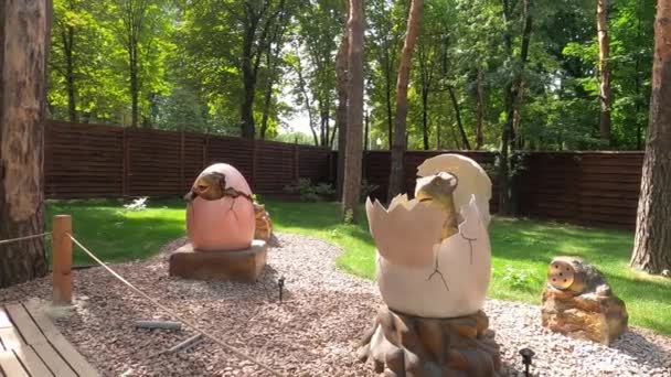 Dino Park Kharkov 2021年8月8日 背景に自然公園内の恐竜の像 小さな恐竜は卵から孵化する 先史時代の動物たちは — ストック動画