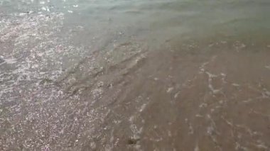Deniz kumsalı, mavi gökyüzü, kum ve güneş. Yazın dalgalı deniz kıyıları