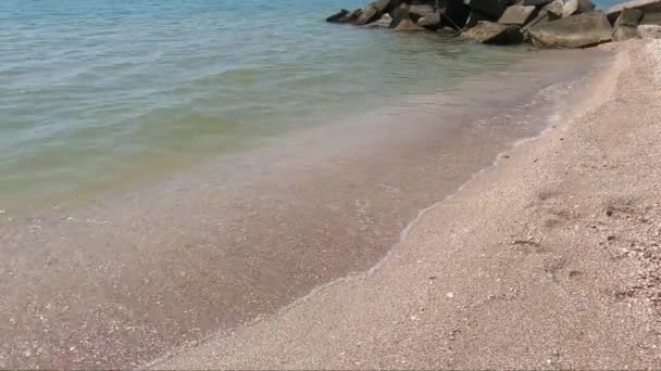해안의 바위들 위에서 청록색 바다가 갈라지면서 모래사장에서 바다에 가르며 부서지는 — 비디오