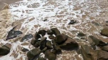 Kaya deniz dalgasını yenmek. Sörf, dalga, ekstrem sporlar.